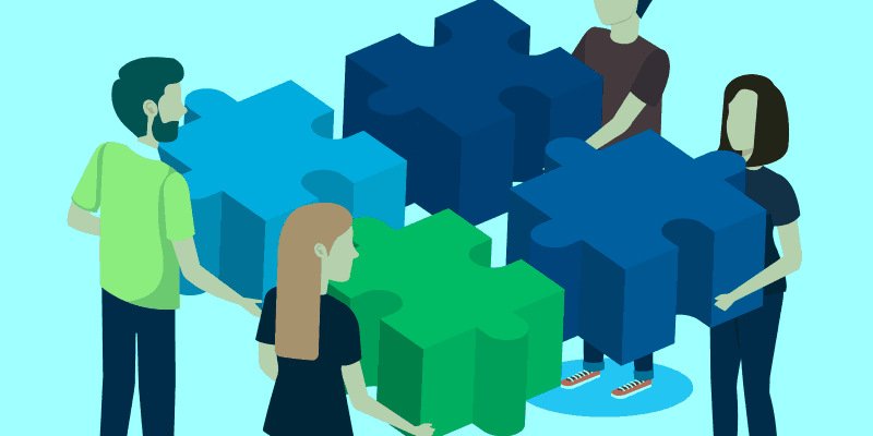 four people facing each other and holding blocks